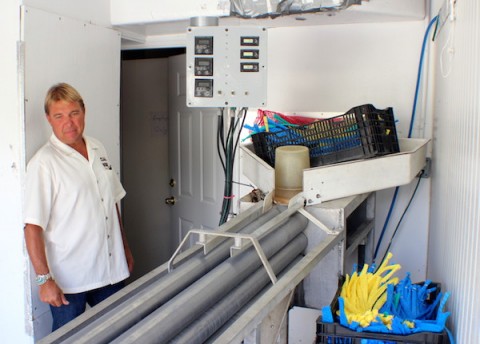 Joe Island Clams owner Kyle Brinkley, with a machine used to sort and bag his Tampa Bay clams / COOPER LEVEY-BAKER