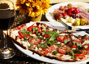 Fresh mozzarella tomato & basil flat bread pizza with antipasto salad from the Main Street Trattoria. (FILE PHOTO)